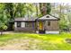 Charming bungalow-style home featuring stone accents, a bright yellow front door, and a well-maintained lawn at 1959 Oana Sw St, Atlanta, GA 30310