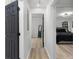 Hallway leads to bedrooms with black doors, wood flooring, and neutral walls at 1959 Oana Sw St, Atlanta, GA 30310