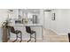 Modern kitchen boasts white cabinets, a marble counter and stainless-steel appliances, with bar stool seating at 1959 Oana Sw St, Atlanta, GA 30310