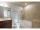 Well-lit bathroom with a double vanity, tiled walls, and a bathtub with a shower, offering a relaxing space at 20 10Th Nw St # 704, Atlanta, GA 30309