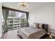 This bedroom features a large window with city views, modern ceiling fan, and wood floors at 20 10Th Nw St # 704, Atlanta, GA 30309