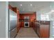A well-lit kitchen with stainless steel appliances, wood cabinets, tile backsplash, and hardwood floors at 20 10Th Nw St # 704, Atlanta, GA 30309