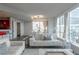This living room features hardwood floors, white furnishings, a bar area, and beautiful city views at 20 10Th Nw St # 704, Atlanta, GA 30309