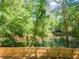 Picturesque backyard with fence and water view framed by mature trees and greenery at 988 Gentry Sw Ln, Marietta, GA 30064