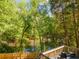 Serene backyard with a pond view framed by lush trees and a deck with chairs at 988 Gentry Sw Ln, Marietta, GA 30064