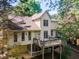 Rear view of a yellow two-story home with a deck overlooking the backyard at 988 Gentry Sw Ln, Marietta, GA 30064