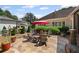 Inviting stone patio features an umbrella, chairs, and lush landscaping, perfect for outdoor entertaining at 11155 Highfield Chase Dr, Johns Creek, GA 30097