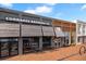 A charming building with black awnings over large glass windows and outdoor seating on a brick-paved walkway at 11155 Highfield Chase Dr, Johns Creek, GA 30097