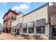 A detailed exterior view of Smokejack restaurant in a brick building with black awnings and outdoor seating at 11155 Highfield Chase Dr, Johns Creek, GA 30097