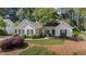Charming one-story home with lush landscaping, black shutters, and attached garage at 11155 Highfield Chase Dr, Johns Creek, GA 30097