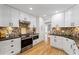 Bright kitchen features white cabinets, a stylish backsplash, stainless appliances and granite counters at 11155 Highfield Chase Dr, Johns Creek, GA 30097