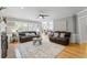 Bright living room features hardwood floors, two couches, ceiling fan, and neutral paint at 11155 Highfield Chase Dr, Johns Creek, GA 30097