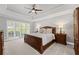 Comfortable bedroom features a tray ceiling, ceiling fan, and a beautiful wood bed at 11155 Highfield Chase Dr, Johns Creek, GA 30097
