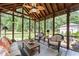 Relaxing screened-in porch with wicker furniture, overlooking a well-manicured lawn and lush greenery at 11155 Highfield Chase Dr, Johns Creek, GA 30097