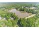 Aerial view of the property featuring a serene lake and lush green trees, providing a peaceful and private retreat at 1609 Holly Ridge Dr, Loganville, GA 30052