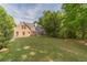 Large backyard featuring green grass, mature trees and the home's covered porch at 1609 Holly Ridge Dr, Loganville, GA 30052