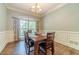 Dining room featuring wainscoting, hardwood floors, and a window at 1609 Holly Ridge Dr, Loganville, GA 30052