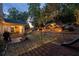 A beautiful backyard at dusk featuring an outdoor dining area, mature landscaping, a playset and stonework at 2580 Glaramara Ter, Cumming, GA 30041