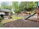 Backyard featuring a playset, a landscaped retaining wall, a covered porch and a barbeque grill at 2580 Glaramara Ter, Cumming, GA 30041