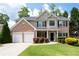 Charming two-story brick home with a well-manicured lawn, two-car garage, and inviting front entrance at 2580 Glaramara Ter, Cumming, GA 30041