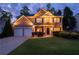 Inviting two-story home with a manicured lawn, a two car garage and a brick facade at 2580 Glaramara Ter, Cumming, GA 30041