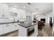 Modern kitchen featuring stainless appliances, white cabinets, granite countertops and center island open to living spaces at 2580 Glaramara Ter, Cumming, GA 30041