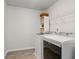 Well-lit laundry room with white washer and dryer, storage shelves, and neutral flooring at 2580 Glaramara Ter, Cumming, GA 30041