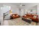 Spacious living room with leather sofas, ceiling fan, staircase and open view of kitchen and breakfast nook at 2580 Glaramara Ter, Cumming, GA 30041