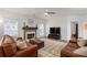 Bright living room featuring a cozy fireplace, comfortable couches, ceiling fan and natural light at 2580 Glaramara Ter, Cumming, GA 30041
