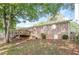 View of the house's brick exterior and deck overlooking the expansive yard, framed by mature trees at 2914 Landmark Se Dr, Conyers, GA 30094