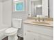 Bathroom with a white vanity, toilet, and a framed mirror above the sink at 3117 Calumet Nw Cir, Kennesaw, GA 30152