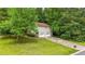 Home featuring a two-car garage and a long driveway, set amidst a backdrop of mature trees and a green lawn at 3117 Calumet Nw Cir, Kennesaw, GA 30152