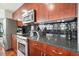 Cherry wood kitchen features stainless steel appliances, granite countertops, and stylish black backsplash at 400 W Peachtree Nw St # 3801, Atlanta, GA 30308
