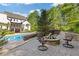 Backyard pool featuring a stone patio, fire pit, seating area, and view of the home's deck at 110 Hawks Bnd, Canton, GA 30115