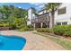 Beautiful backyard oasis featuring an in-ground pool, a covered deck, a spacious patio area, and lush landscaping at 110 Hawks Bnd, Canton, GA 30115