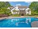 Luxurious backyard with a large in-ground pool, a covered deck, mature landscaping, and a spacious patio area at 110 Hawks Bnd, Canton, GA 30115
