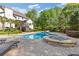 Beautiful backyard featuring an in-ground pool, hot tub, lounge chairs, a covered patio, and lush landscaping at 110 Hawks Bnd, Canton, GA 30115