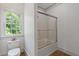 Modern bathroom showcasing a toilet, shower-tub, and large window at 110 Hawks Bnd, Canton, GA 30115