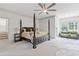 Spacious bedroom featuring a four-poster bed, sitting area, ceiling fan, and wood floors at 110 Hawks Bnd, Canton, GA 30115