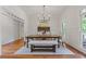 Bright dining room featuring a wooden table, chandelier, and natural light from the windows at 110 Hawks Bnd, Canton, GA 30115