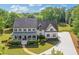 Charming two-story home boasting a welcoming front porch, lush landscaping, and a long driveway on a sunny day at 110 Hawks Bnd, Canton, GA 30115