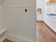 Hallway features white wood paneling leading to a kitchen with hardwood floors and white cabinetry at 110 Hawks Bnd, Canton, GA 30115