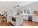 Open-concept kitchen featuring a central island, modern appliances, white cabinets, and hardwood floors at 110 Hawks Bnd, Canton, GA 30115