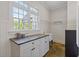 Bright laundry room with granite countertop, white cabinets, large windows and wood paneling at 110 Hawks Bnd, Canton, GA 30115