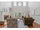 Bright living room with a fireplace, large windows, hardwood floors, and comfortable seating arrangements at 110 Hawks Bnd, Canton, GA 30115