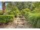 Exterior stone pathway surrounded by lush landscaping leading up to a beautiful backyard at 110 Hawks Bnd, Canton, GA 30115
