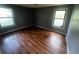 Bedroom with grey walls, two windows for ample light, and wood floors throughout at 1310 Muirforest Way, Stone Mountain, GA 30088