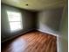 Bedroom with grey walls, a window for ample light, and wood floors throughout at 1310 Muirforest Way, Stone Mountain, GA 30088