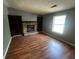 Cozy living room featuring hardwood floors, a brick fireplace, and built-in shelving at 1310 Muirforest Way, Stone Mountain, GA 30088