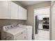 Convenient laundry room with white cabinetry and appliances at 15104 Harvest Ridge Ln, Alpharetta, GA 30022